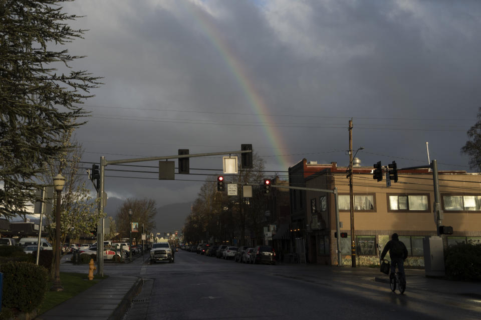 A rainbow appears over the downtown area of Grants Pass, Friday, March 22, 2024. (AP Photo/Jenny Kane)