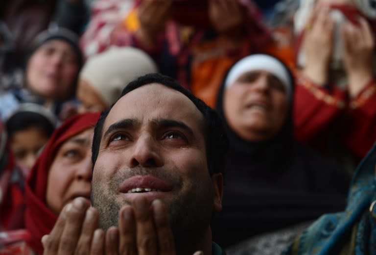 <p>Kashmiri Muslims offer prayers as an unseen clergyman displays a relic at the shrine of Sheikh Abdul Qadir Geelani in Srinagar on January 29, 2016. Devotees are marking the last Friday of Urs (Festival) of the saint who lived in Baghdad some 1,000 years ago and is buried there. Kashmiri Muslims hold the saint in high esteem and have set up scores of shrines and mosques in his memory. </p>