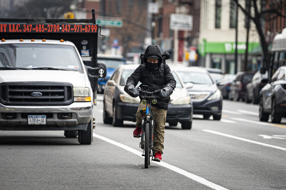 Un repartidor de comida en bicicleta circula hacia el norte por la avenida Flatbush el jueves 1 de febrero de 2024 en Nueva York. Una nueva norma en Nueva York para proteger los ingresos de los repartidores ha encontrado una reacción en contra de compañías como Uber, GrubHub y DoorDash, que han reducido las horas de los trabajadores y complicado las propinas. (AP Foto/Peter K. Afriyie)