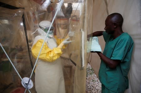 FILE PHOTO: A health worker wearing Ebola protection gear enters the Biosecure Emergency Care Unit at the ALIMA Ebola treatment centre in Beni