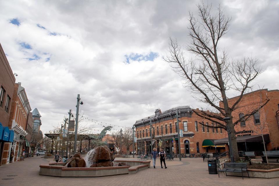 People hang out in Old Town Square in Fort Collins on Wednesday.