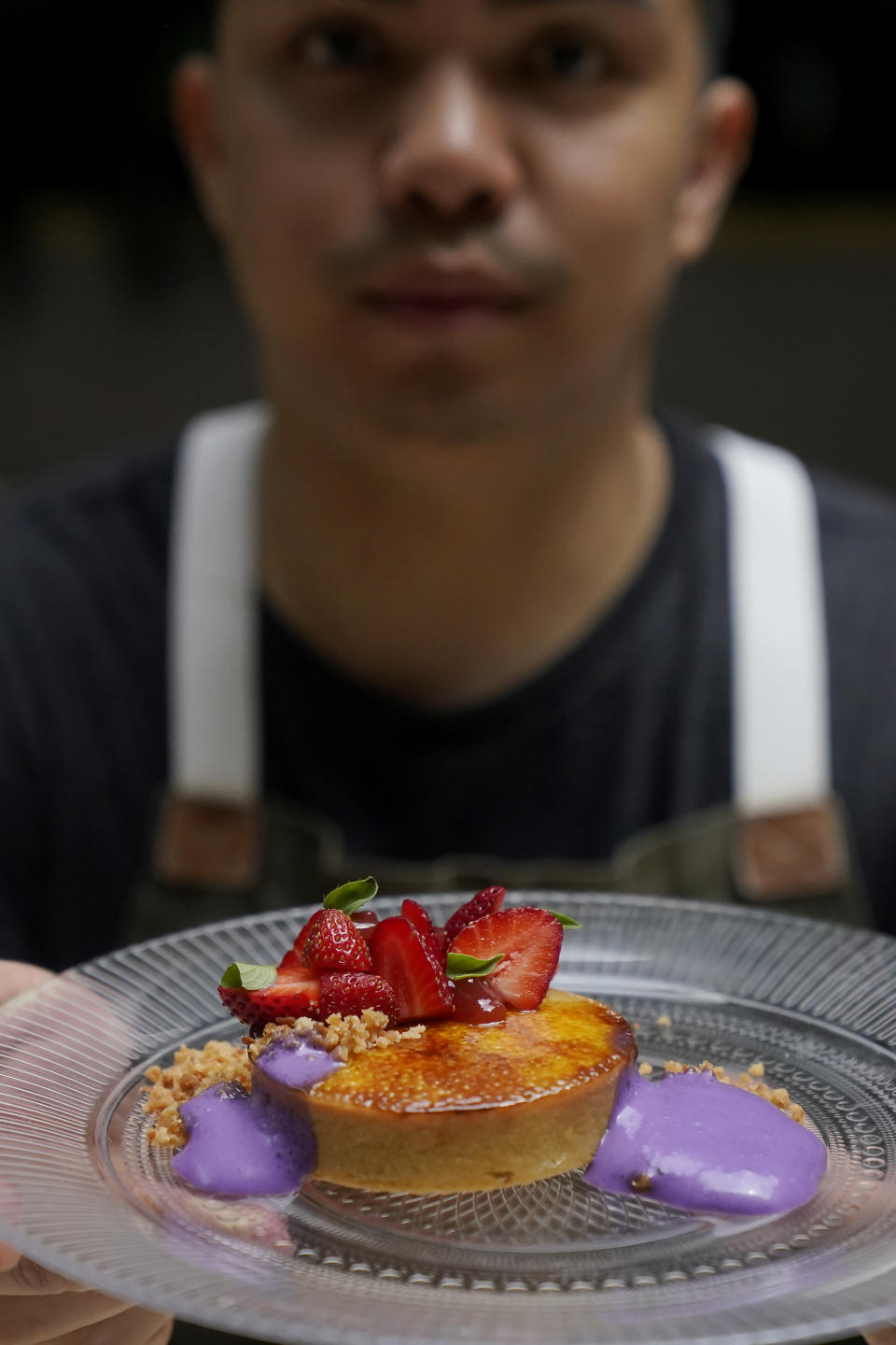 Pastry chef Vince Bugtong holds a Crème Brûlée Tart, made of lemon cinnamon custard, strawberry guava jam, macadamia coconut streusel and ube espuma, a purple yam foam, at Abaca restaurant in San Francisco, Monday, May 29, 2023. Three Filipino restaurants in three different areas of the U.S. will be representing at this year's James Beard Awards, the culinary world's equivalent of the Oscars. The awards ceremony is next week in Chicago. (AP Photo/Jeff Chiu)