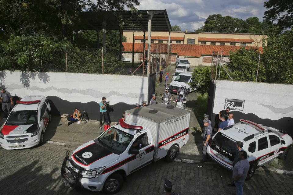 Forensic vehicles transport the bodies of the people who were killed in the school shooting. Source: AP