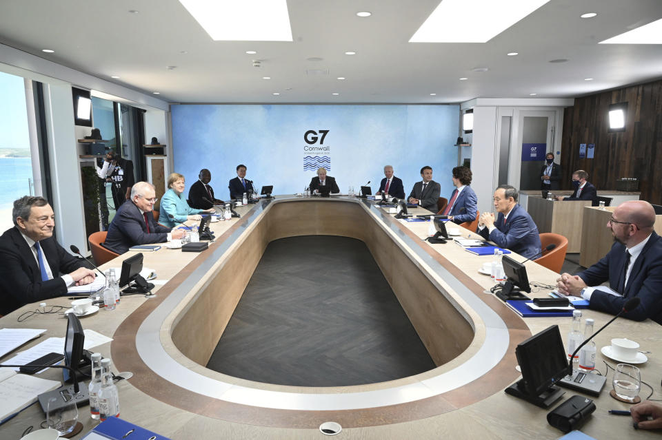 Britain's Prime Minister Boris Johnson, center, with from left, Italy's Prime Minister Mario Draghi, Australia's Prime Minister Scott Morrison, German Chancellor Angela Merkel, South Africa's President Cyril Ramaphosa, South Korea's President Moon Jae-in, US President Joe Biden, French President Emmanuel Macron, Canada's Prime Minister Justin Trudeau, Japan's Prime Minister Yoshihide Suga and President of the European Council Charles Michel during the G7 summit in Cornwall, England, Saturday June 12, 2021. (Leon Neal/Pool via AP)