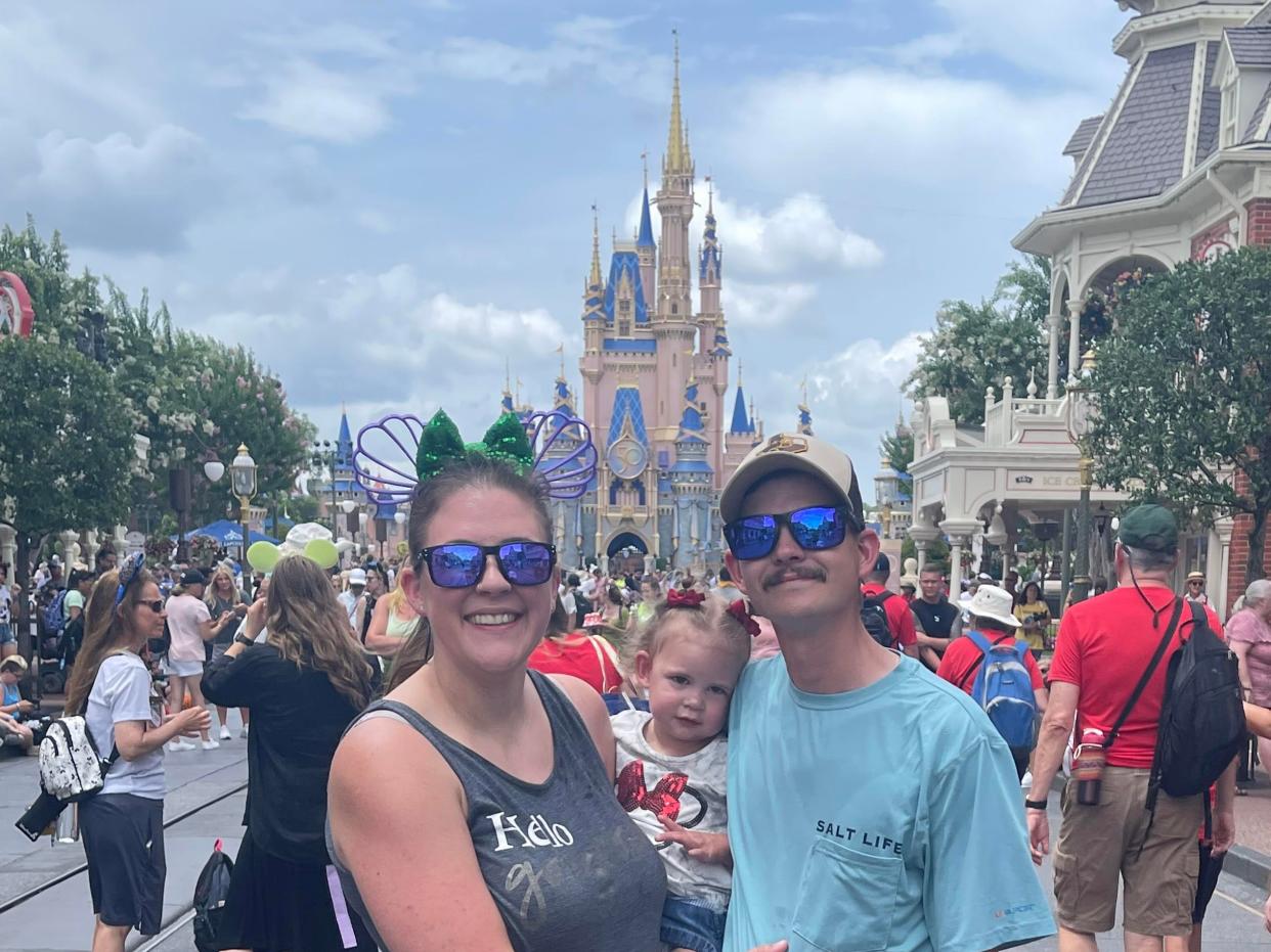 Photo of Holly and Cody Cole at Disney World with their daughter.
