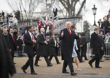 U.S. President Donald Trump gestures while walking with wife Melania and son Barron during the Inaugural Parade in Washington, January 20, 2017. Donald Trump was sworn in earlier as the 45th President of the United States. REUTERS/Carlos Barria