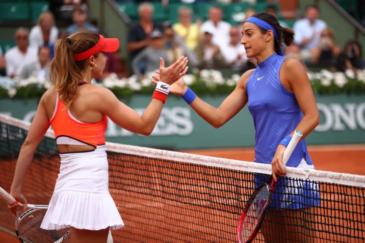 Caroline Garcia (blue) shakes hands with fellow French player Alize Cornet (orange) after their match. (Getty Images)
