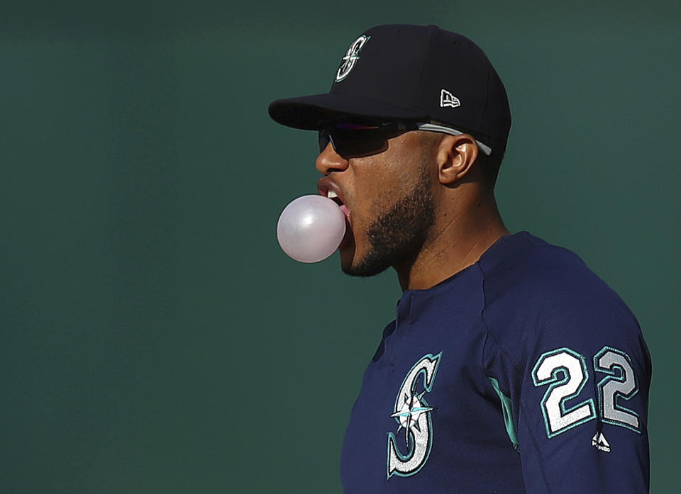 Seattle Mariners' Robinson Cano blows bubble gum during batting practice prior to a baseball game against the Oakland Athletics Tuesday, Aug. 14, 2018, in Oakland, Calif. Cano is returning after an 80-game drug suspension. The All-Star second baseman last played May 15. (AP Photo/Ben Margot)