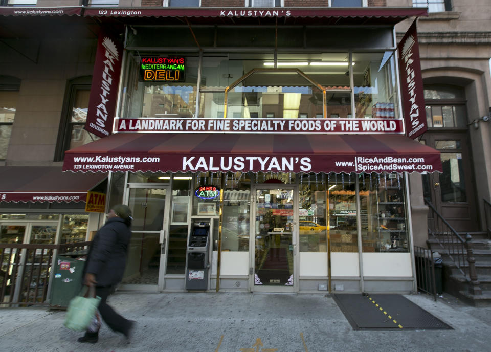 In this Nov. 21, 2013 photo, a woman passes Kalustyan's Indian/Middle Eastern spice and specialty food shop nestled into a row of like-minded stores on New York's Lexington Avenue. The not-so-little gem of a shop is known to New Yorker foodies, but off the map for most tourists. (AP Photo/Richard Drew)