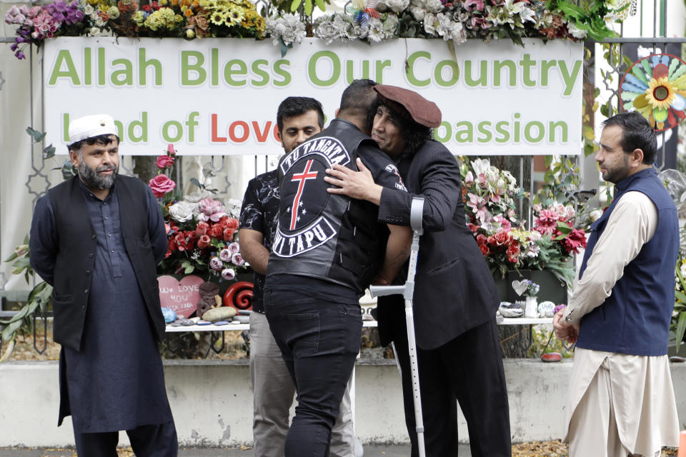 Survivor of the Al Noor mosque shootings, Taj Mohammed Kamran, second from right, welcomes a member of the Tu Tangata motorcycle club to the Al Noor mosque in Christchurch, New Zealand, Sunday, March 15, 2020. A national memorial in New Zealand to commemorate the 51 people who were killed when a gunman attacked two mosques one year ago has been canceled due to fears over the new coronavirus. (AP Photo/Mark Baker)