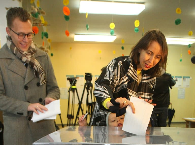 A voter casts his ballot at a polling station during parliamentary elections in Lithuania's capital Vilnius on October 9, 2016