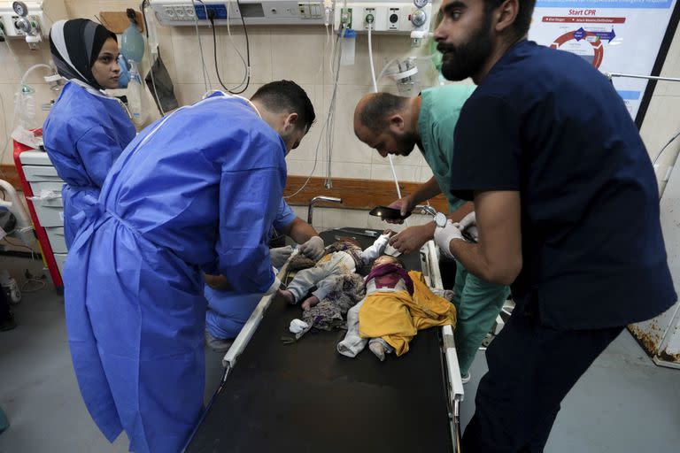 Médicos atienden a niños heridos en un bombardeo israelí en la Franja de Gaza, en un hospital en Deir Al-Balah, el miércoles 25 de octubre de 2023