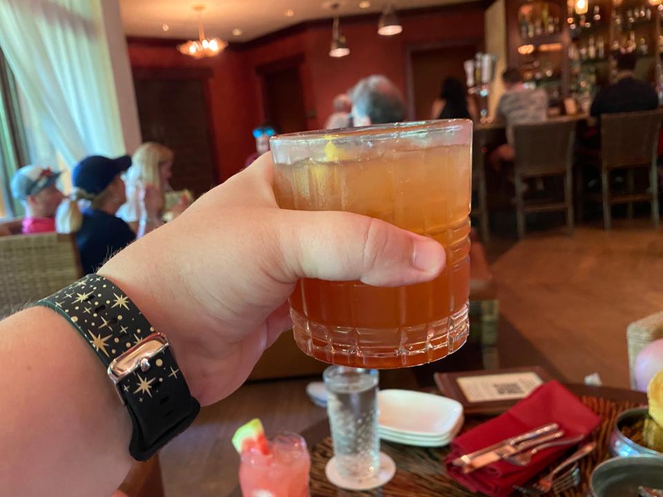 The writer holds a Tempting Tigress cocktail at Nomad Lounge