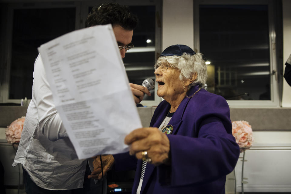 A holocaust survivor sing during an event named 'Survivors Night' in Paris, Monday, Dec. 23, 2019. Holocaust survivors in several cities around the world are lighting candles for Hanukkah together, as Jewish community leaders try to keep first-hand memories of the Nazi horrors alive. The events were organized by the Conference on Jewish Material Claims Against Germany. (AP Photo/Kamil Zihnioglu)