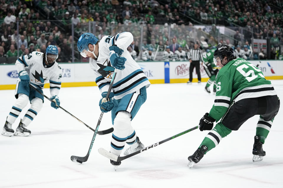 San Jose Sharks center Ryan Carpenter (22) takes control of the puck in front of Dallas Stars defenseman Thomas Harley (55) in the first period of an NHL hockey game Saturday, March 2, 2024, in Dallas. (AP Photo/Tony Gutierrez)