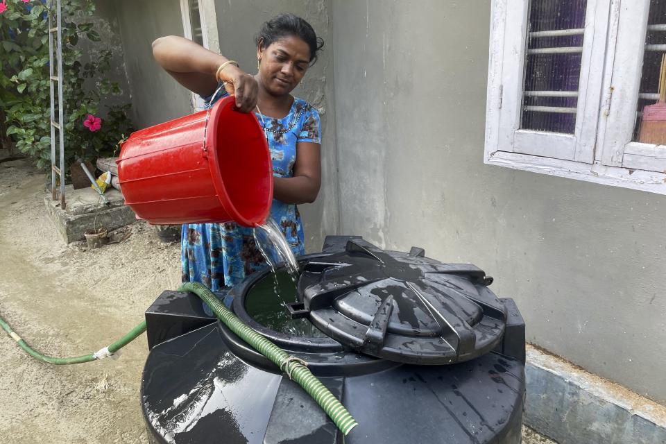 A woman pours water in a tanker at her home in the Chellanam area of Kochi, Kerala state, India, March 1, 2023, after collecting water in buckets from the main road. Saltwater's intrusion into freshwater is a growing problem linked to climate change and in Chellanam rising salinity means residents can no longer depend on ponds and wells for the water they need to drink, cook and wash. (Uzmi Athar/Press Trust of India via AP)
