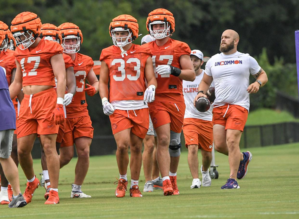 Ben Boulware, right, starting linebacker with the 2017 National Championship game team, helps as a football intern, during the Clemson first football August practice in Clemson, S.C. Thursday August 1, 2024.