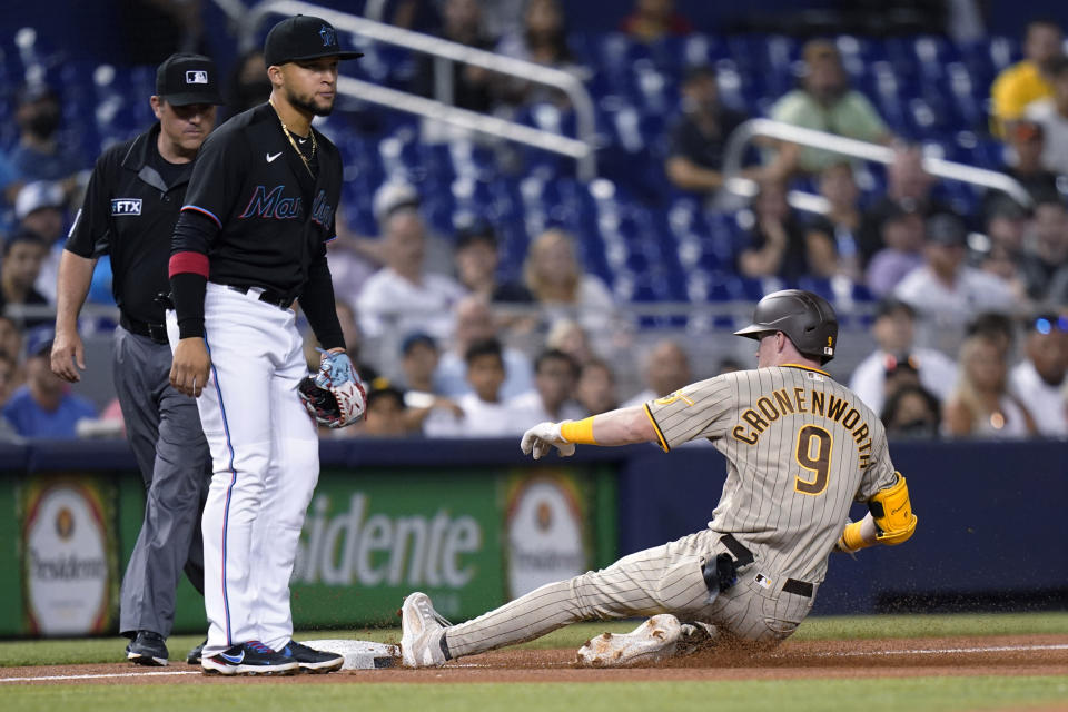 San Diego Padres' Jake Cronenworth (9) beats the throw to Miami Marlins third baseman Isan Diaz for a triple during the first inning of a baseball game Friday, July 23, 2021, in Miami. (AP Photo/Lynne Sladky)