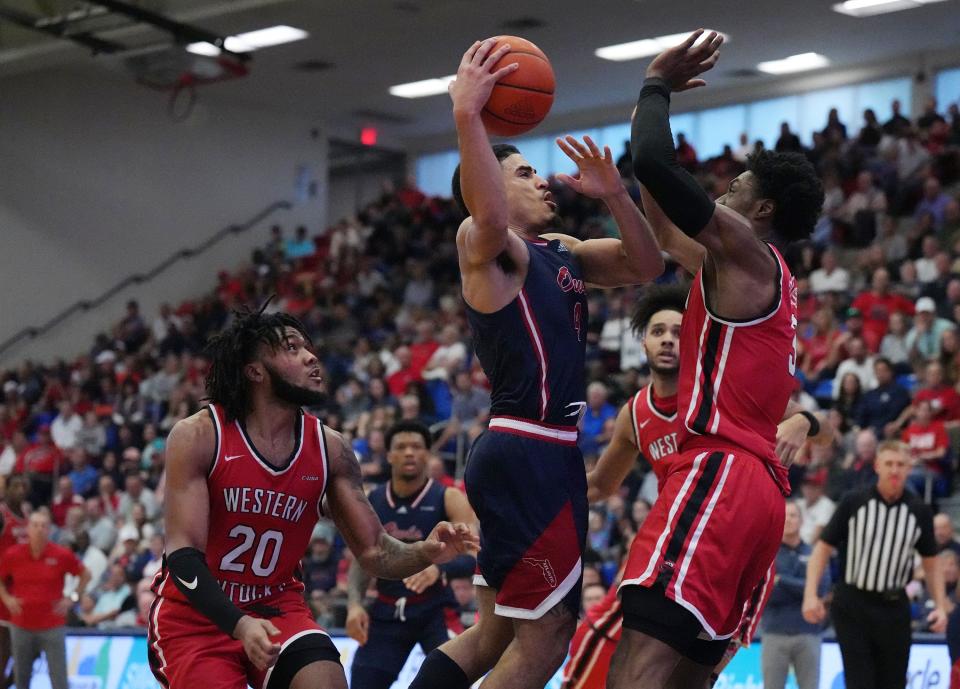 Jan 28, 2023; Boca Raton, Florida, USA; Florida Atlantic Owls guard Bryan Greenlee (4) goes up for a shot as Western Kentucky Hilltoppers forward Jairus Hamilton (3) and guard Dayvion McKnight (20) close in during the second half at Eleanor R. Baldwin Arena. Mandatory Credit: Jim Rassol-USA TODAY Sports