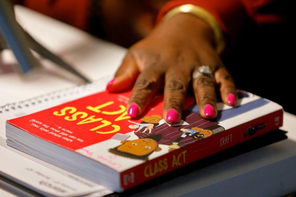 Yolanda Taylor rests her hand on top of the book ”Class Act,” by Jerry Craft, inside her home office Wednesday evening in Wake Forest March 8, 2023.