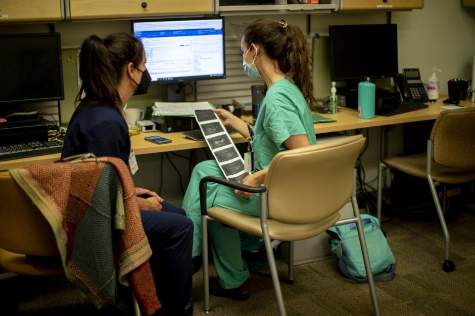 A physician and her resident look over an ultrasound