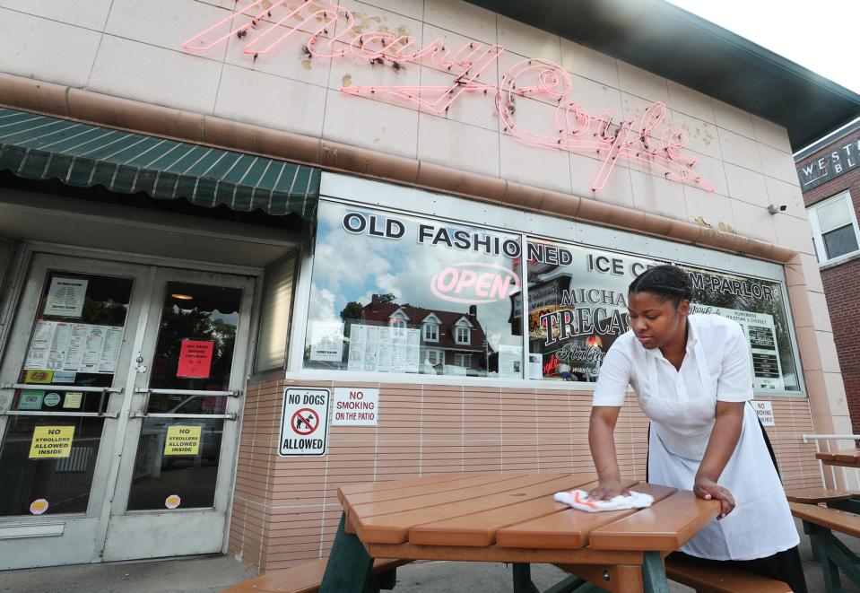 Bobbie Jackson, who has been working at Michael Trecaso's Mary Coyle for 10 years, wipes down a table in the outside patio in Highland Square in Akron on Wednesday June 9, 2021. The restaurant ice cream shop is currently carry out only.