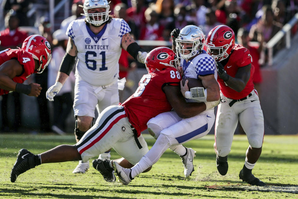 Kentucky quarterback Will Levis (7) is sacked by Georgia defensive lineman Jalen Carter (88) and linebacker Quay Walker (7) during the first half of an NCAA college football game Saturday, Oct. 16, 2021 in Athens, Ga. (AP Photo/Butch Dill)