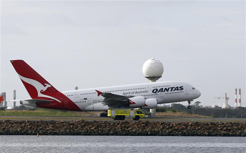 A Qantas plane A380 passes an emergency vehicle as it takes off from Kingsford Smith International airport in Sydney