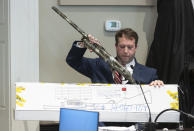 Firearms examiner Paul Greer removes a shotgun from an evidence box during Alex Murdaugh's double murder trial at the Colleton County Courthouse in Walterboro, S.C., Friday, Feb. 3, 2023. The 54-year-old attorney is standing trial on two counts of murder in the shootings of his wife and son at their Colleton County home and hunting lodge on June 7, 2021. (Sam Wolfe/The State via AP, Pool)