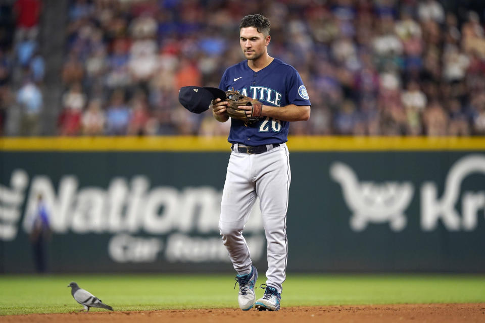 Seattle Mariners second baseman Adam Frazier (26) looks at a pigeon on the infield during the third inning of the team's baseball game against the Texas Rangers in Arlington, Texas, Saturday, Aug. 13, 2022. (AP Photo/LM Otero)