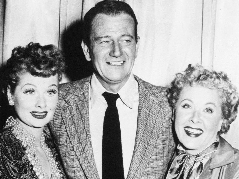 Lucille Ball and Vivian Vance pose with John Wayne