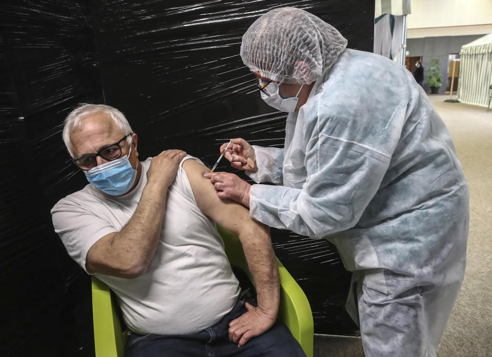 FILE - In this Jan.18, 2021 file photo a medical staff administers the Pfizer-BioNTech vaccine against COVID-19 at a vaccination center at a gymnasium in Versailles west of Paris. Countries in the European Union have ramped up the vaccination after sluggish start. The uptick comes as countries across Europe also grapple with a rise in infections that has pushed the EU’s overall number of confirmed cases close to 30 million. (AP Photo/Michel Euler,file)