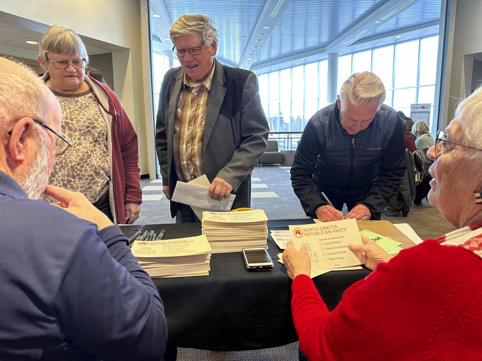 Claus, left, and Marsha Lembke, right, handle ballots for Republican caucus voters on Monday, March 4, 2024, at Bismarck State College in Bismarck, N.D. The college is one of 12 sites for the North Dakota Republican caucuses. (AP Photo/Jack Dura)