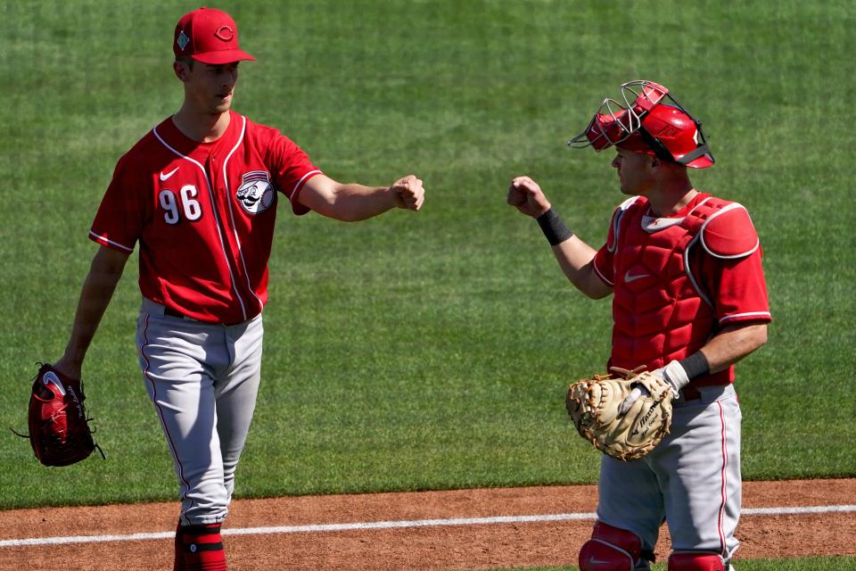 Cincinnati Reds non-roster invitee pitcher Brandon Williamson (96) fist bumps Cincinnati Reds non-roster invitee catcher Andrew Knapp (35) during a spring training baseball game against the Cleveland Guardians, Friday, March 18, 2022, at Goodyear Ballpark Goodyear, Ariz.