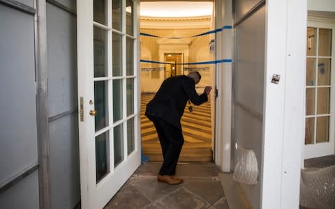 A Secret Service agent checks on the Oval Office of the White House in Washington, Friday, Aug. 11, 2017, as the West Wing of the White House in Washington is undergoing renovations while President Donald Trump is spending time at his golf resort in New Jersey - Credit: AP