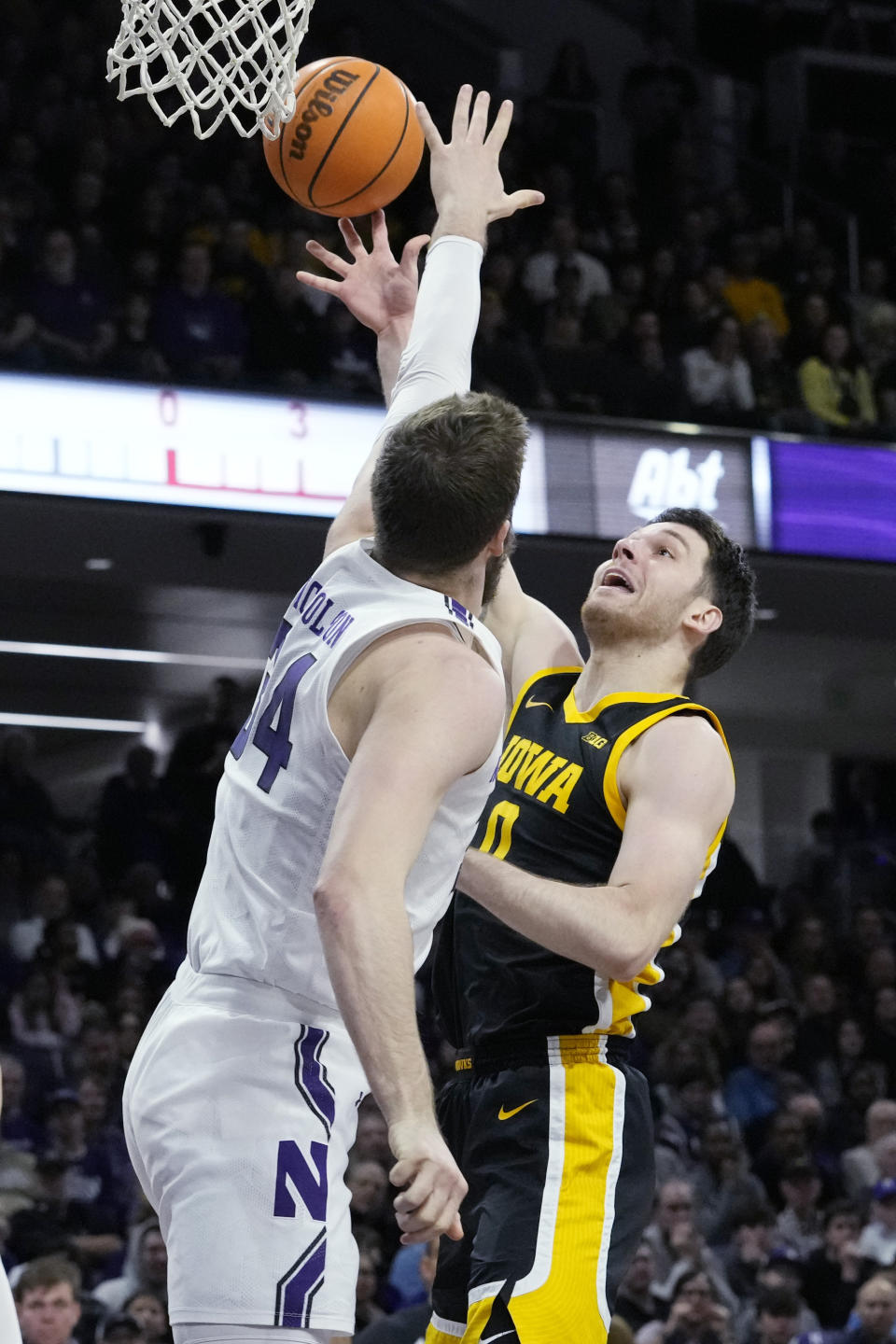 Iowa forward Filip Rebraca, right, shoots over Northwestern center Matthew Nicholson during the first half of an NCAA college basketball game in Evanston, Ill., Sunday, Feb. 19, 2023. (AP Photo/Nam Y. Huh)