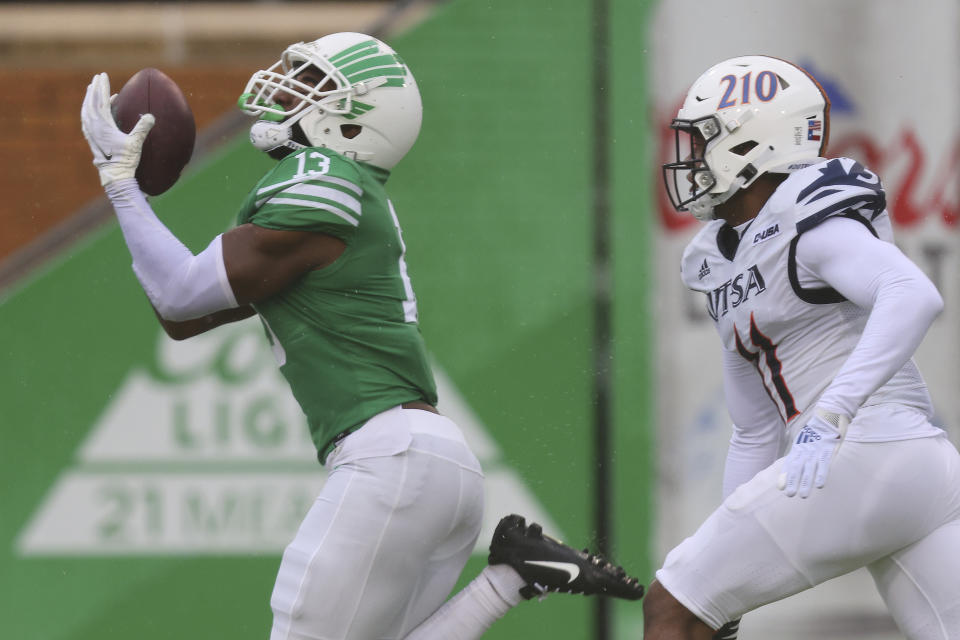 North Texas wide receiver Khatib Lyles makes a catch while being defended by UTSA safety Kelechi Nwachuku during the second half of an NCAA college football game in Denton, Texas, Saturday, Nov. 27, 2021. (AP Photo/Andy Jacobsohn)