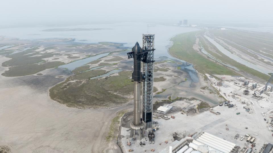 SpaceX's Starship and Super Heavy booster are seen on the company's launch mount near at Starbase, Texas, in April 2023. This booster and Starship are slated to fly the first orbital test flight.