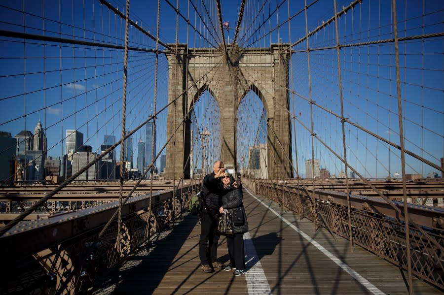 A couple takes a photograph on the Brooklyn Bridge, December 1, 2017 in New York City. (Photo by Drew Angerer/Getty Images)