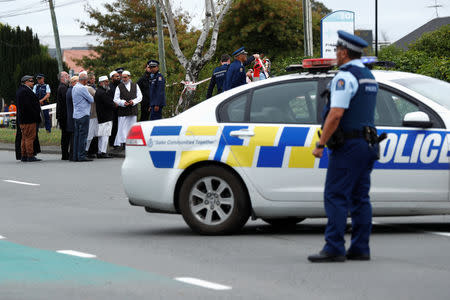 Police stand guard as members of Muslim religious groups gather for prayers at the site of the shooting outside Linwood Mosque in Christchurch, New Zealand March 18, 2019. REUTERS/Edgar Su