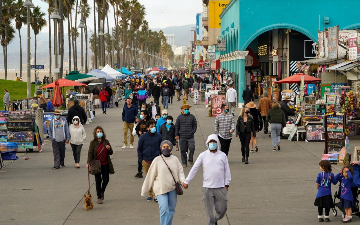 People stroll on the Venice Beach Boardwalk in Los Angeles, December 2020 - Damian Dovarganes /AP