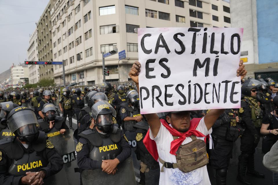A supporter of ousted President Pedro Castillo holds a poster with a message that reads in Spanish: "Castillo is my president" near Congress in Lima, Peru, Friday, Dec. 9, 2022. Peru's Congress voted to remove President Pedro Castillo from office Wednesday and replace him with the vice president, shortly after Castillo tried to dissolve the legislature ahead of a scheduled vote to remove him. (AP Photo/Martin Mejia)