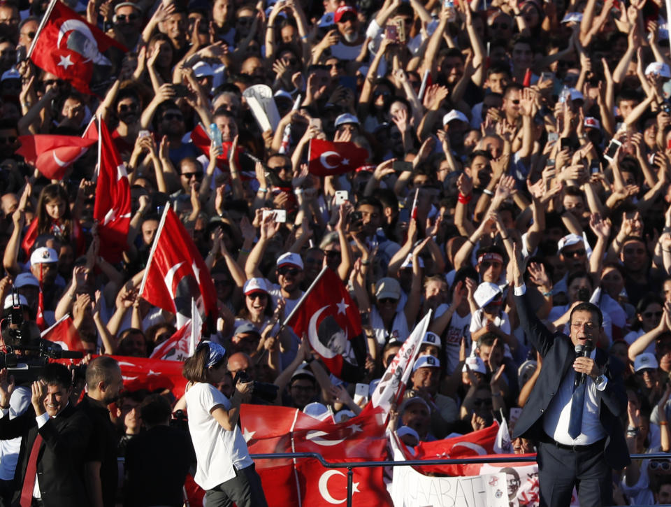 Ekrem Imamoglu, bottom right, the new Mayor of Istanbul from Turkey's main opposition opposition Republican People's Party (CHP) talks as thousands of supporters surround his campaign bus, after he took over office, in Istanbul, Thursday, June 27, 2019. Imamoglu is formally taking office as mayor of Istanbul four days after he won a repeat election in Turkey's largest city and commercial hub. (AP Photo/Lefteris Pitarakis)