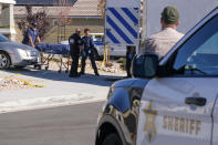 Los Angeles County Coroner officials remove a body from a home where five bodies were found in the city of Lancaster in the high desert Antelope Valley north of Los Angeles, Monday, Nov. 29, 2021. A Los Angeles County Sheriff's Department statement says deputies found a woman, a girl and three boys with gunshot wounds and paramedics pronounced them dead at the scene. The department says the children's father showed up at the Lancaster sheriff's station and was arrested on suspicion of five murders after being interviewed by detectives. (AP Photo/Ringo H.W. Chiu)