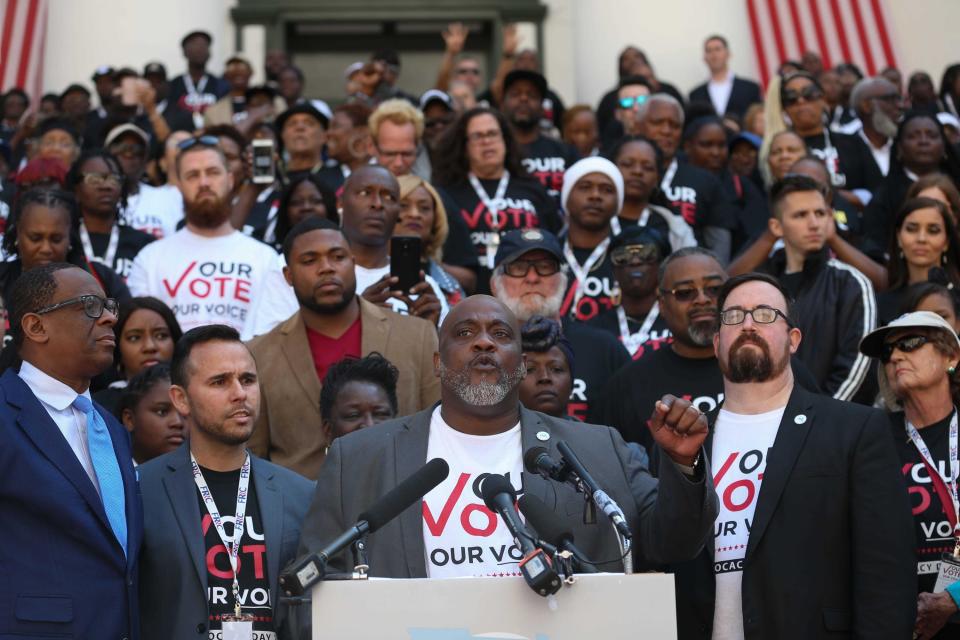 Desmond Meade, the president of the Florida Rights Restoration Coalition (center), speaks in front of Floridians with felony convictions on March 12, 2020, in Tallahassee, Fla. Voters passed a constitutional amendment in 2018 designed to give them their right to vote, but in September 2020, the 11th Circuit Court of Appeals upheld a state law that requires them to repay all courts fees, fines and restitution before they can vote.
