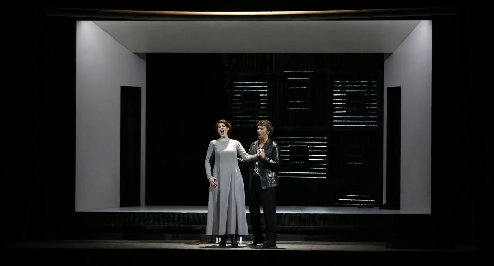 In this picture taken Friday, June 21, 2013, Jonas Kaufmann, right, in the role of Manrico and Anja Harteros as Leonora sing during a dress rehearsal for the opera "Il Trovatore" by Giuseppe Verdi in the Bavarian State Opera House in Munich, southern Germany. This wild new production by Olivier Py opened the company's annual Munich Opera Festival. It's a non-stop barrage of nightmarish images mixing styles and periods that assault the audience at lightning speed on a multi-tiered revolving set. (AP Photo/Matthias Schrader)