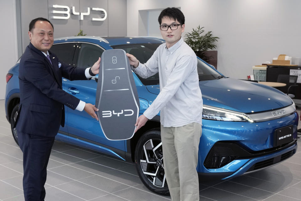 Ohta, who just bought a brand new BYD ATTO 3 electric sports utility vehicle, poses with a symbolically-made key handed by Kazuhisa Okamoto, head of the Yokohama BYD dealership on April 4, 2023, in Yokohama near Tokyo. BYD Auto is part of a wave of Chinese electric car exporters that are starting to compete with Western and Japanese brands in their home markets. They bring fast-developing technology and low prices that Tesla Inc.'s chief financial officer says “are scary.” (AP Photo/Eugene Hoshiko)