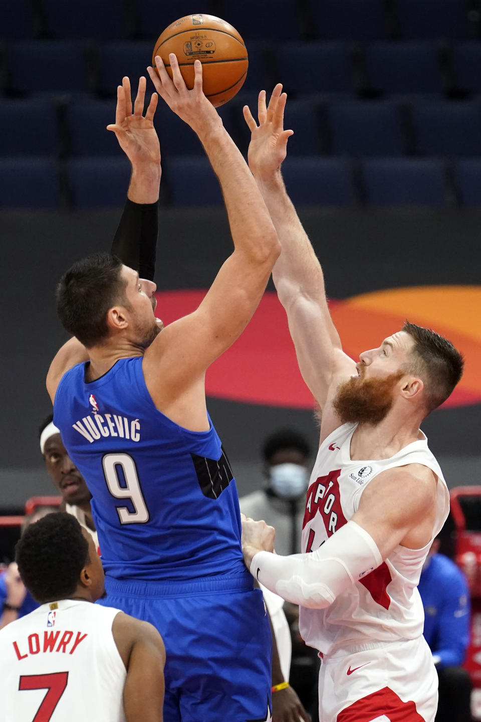 Orlando Magic center Nikola Vucevic (9) shoots over Toronto Raptors center Aron Baynes (46) and guard Kyle Lowry (7) during the second half of an NBA basketball game Sunday, Jan. 31, 2021, in Tampa, Fla. (AP Photo/Chris O'Meara)