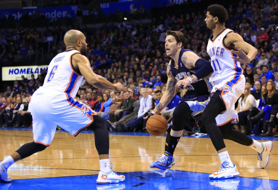 Memphis Grizzlies small forward Mike Miller, second from right, drives to the basket between Oklahoma City Thunder guard Derek Fisher (6) and Jeremy Lamb (11) during the second quarter of an NBA basketball game on Monday, Feb. 3, 2014, in Oklahoma City. (AP Photo/Alonzo Adams)