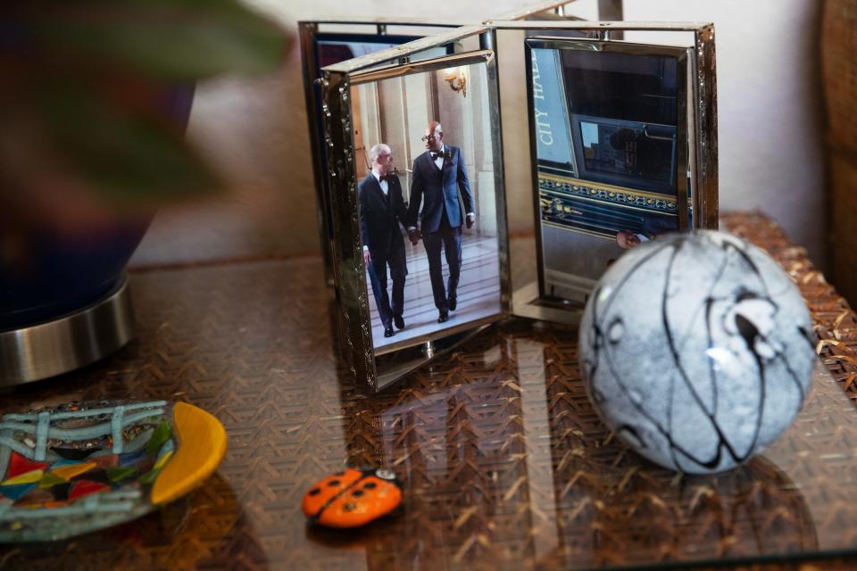 A photograph of Paul Edmonds and his husband, Arnie House, from their wedding day sits on a table inside their Desert Hot Springs, California, home on April 6, 2023. Edmonds is one of five people worldwide in full remission from HIV after undergoing a stem cell transplant.